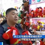 A vendor at Yiwu International Trade Market in Zhejiang, China, displays red Chinese zodiac Horse-themed plush toys during preparations for Lunar New Year 2026, with shelves filled with various horse-shaped stuffed animals in the background.